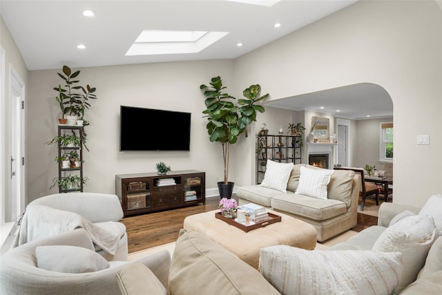 755 Webster Ave, New Rochelle, NY 10804 - living area featuring a skylight, recessed lighting, wood finished floors, a lit fireplace, and arched walkways