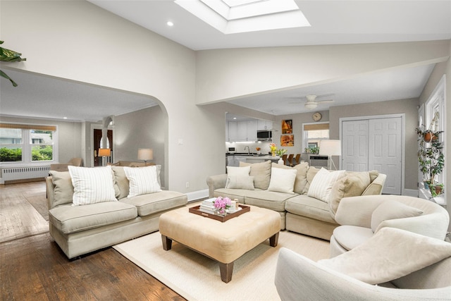 755 Webster Ave, New Rochelle, NY 10804 - living area with radiator heating unit, hardwood / wood-style floors, arched walkways, a skylight, and high vaulted ceiling