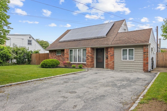 2287 7th St, East Meadow, NY 11554 - view of front of property with solar panels, roof with shingles, asphalt driveway, and brick siding