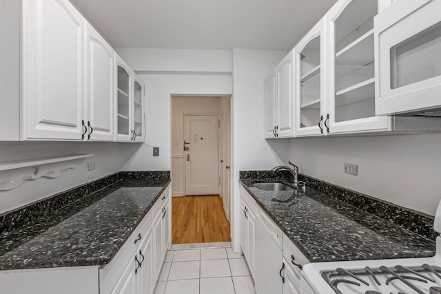 123-35 82nd Rd Unit 4H, Kew Gardens, NY 11415 - kitchen featuring white microwave, a sink, glass insert cabinets, white cabinetry, and dark stone counters
