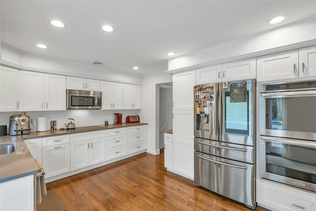 45 Pool Dr, Roslyn, NY 11576 - kitchen featuring stainless steel appliances, white cabinetry, dark wood finished floors, and recessed lighting