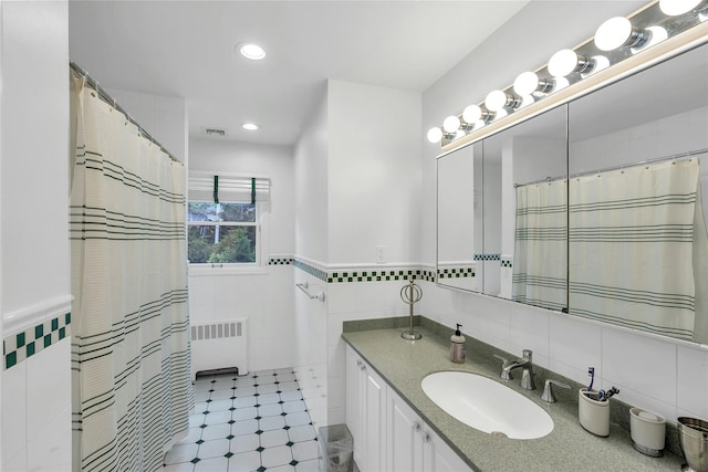 45 Pool Dr, Roslyn, NY 11576 - bathroom featuring tile walls, radiator, vanity, recessed lighting, and wainscoting