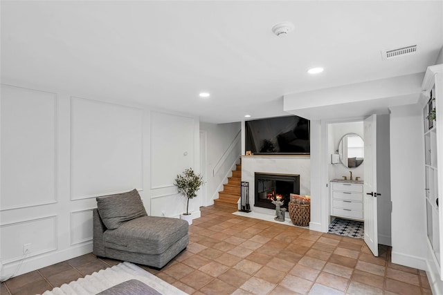 45 Pool Dr, Roslyn, NY 11576 - living area featuring a decorative wall, a premium fireplace, recessed lighting, and stairs