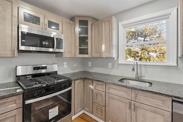 945 Homestead Ave, Maybrook, NY 12543 - kitchen featuring stainless steel appliances, a sink, dark stone countertops, glass insert cabinets, and light brown cabinetry
