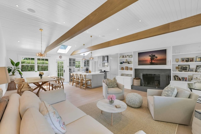 2 Longview Rd, Southampton, NY 11968 - living area featuring a glass covered fireplace, light wood-style floors, a skylight, a chandelier, and recessed lighting