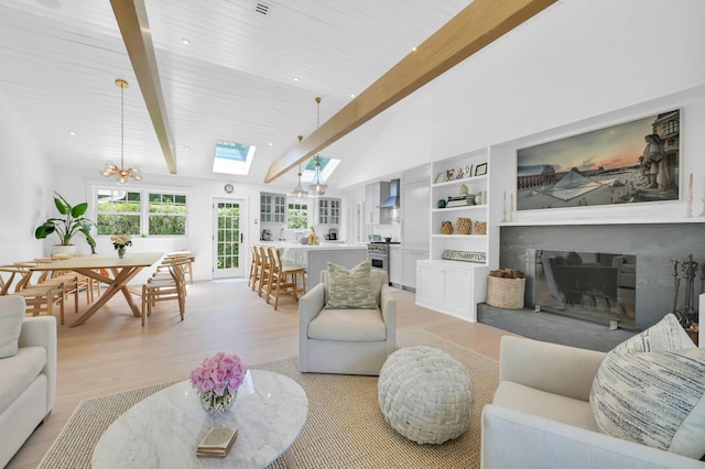 2 Longview Rd, Southampton, NY 11968 - living room with a chandelier, a skylight, light wood-style floors, and a glass covered fireplace