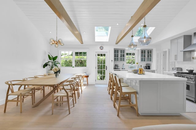 2 Longview Rd, Southampton, NY 11968 - kitchen with stainless steel range, a skylight, light wood-type flooring, light countertops, and glass insert cabinets