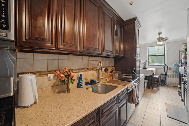 60 Barker St Unit 417, Mount Kisco, NY 10549 - kitchen featuring a sink, radiator, light tile patterned floors, decorative backsplash, and dark brown cabinets
