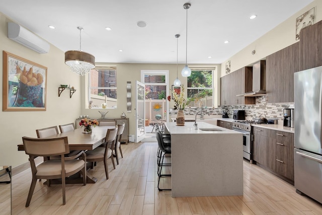 459 Vanderbilt Ave, Brooklyn, NY 11238 - kitchen featuring stainless steel appliances, a sink, a wall mounted air conditioner, modern cabinets, and wall chimney exhaust hood