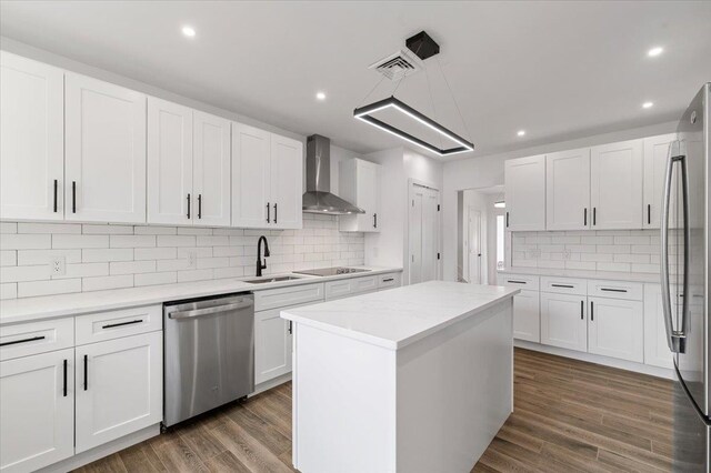 559 Linda Ln, Woodmere, NY 11598 - kitchen with appliances with stainless steel finishes, a sink, wall chimney exhaust hood, tasteful backsplash, and white cabinets