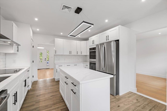 559 Linda Ln, Woodmere, NY 11598 - kitchen featuring stainless steel appliances, light wood-style floors, backsplash, a center island, and recessed lighting