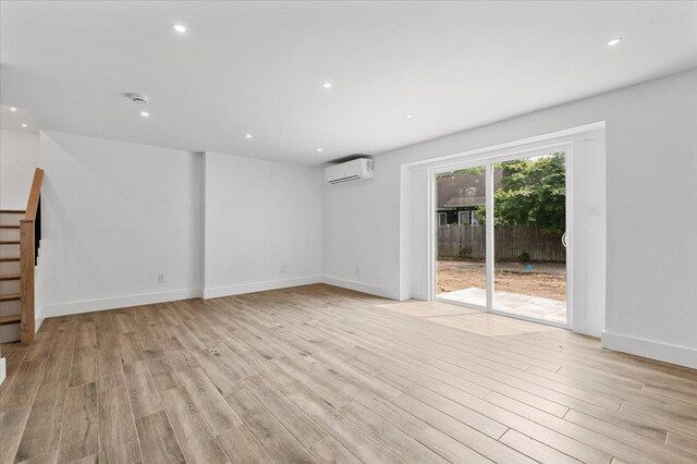559 Linda Ln, Woodmere, NY 11598 - spare room featuring light wood-style flooring, stairs, a wall mounted air conditioner, baseboards, and recessed lighting