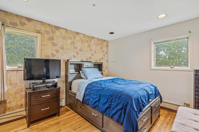 48 Fairfield Dr, Dix Hills, NY 11746 - bedroom with wallpapered walls, a baseboard radiator, light wood finished floors, baseboards, and an accent wall