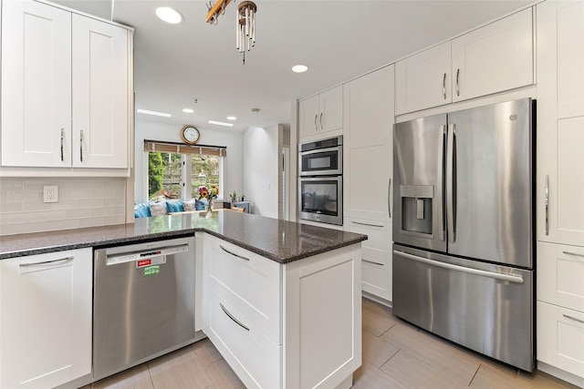 41 Boulder Ridge Rd, Scarsdale, NY 10583 - kitchen featuring appliances with stainless steel finishes, a peninsula, white cabinetry, recessed lighting, and tasteful backsplash