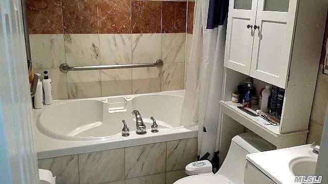569 Peninsula Blvd, Cedarhurst, NY 11516 - bathroom featuring toilet, vanity, and shower / tub combo with curtain