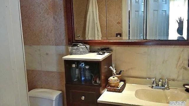 569 Peninsula Blvd, Cedarhurst, NY 11516 - bathroom with vanity, tile walls, and toilet