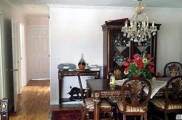 569 Peninsula Blvd, Cedarhurst, NY 11516 - dining area with wood finished floors, a chandelier, and crown molding