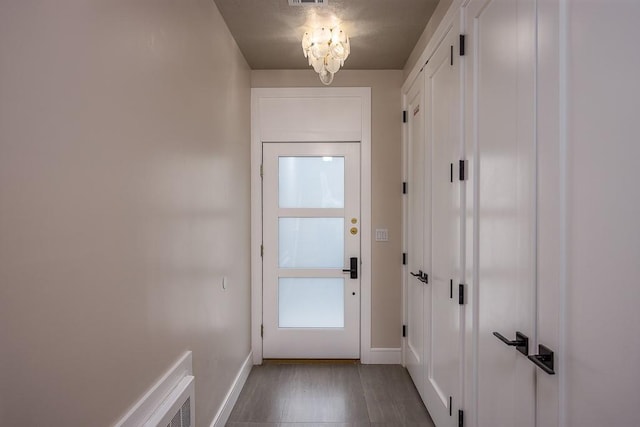 15 Old Nyack Tpke Unit 201, Monsey, NY 10952 - doorway to outside with a chandelier, baseboards, and dark wood-style flooring