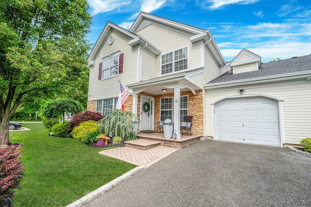 4 Cari Ln, Middle Island, NY 11953 - traditional-style house with covered porch, a garage, a front lawn, stone siding, and driveway