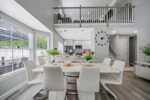 4 Cari Ln, Middle Island, NY 11953 - dining area with wood finished floors, baseboards, stairway, and a high ceiling