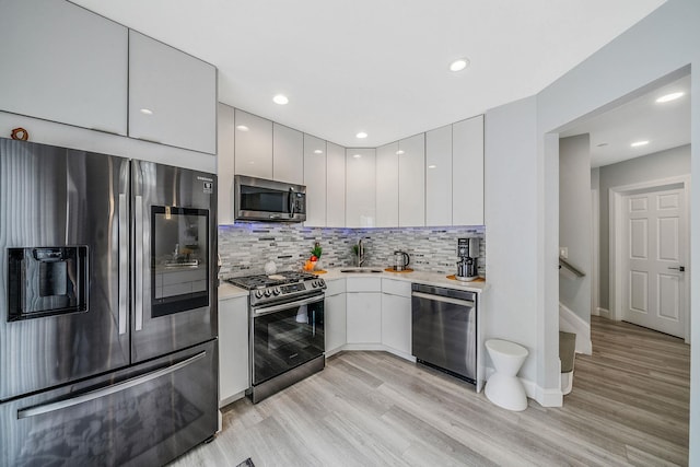 4 Cari Ln, Middle Island, NY 11953 - kitchen featuring stainless steel appliances, a sink, light countertops, modern cabinets, and recessed lighting