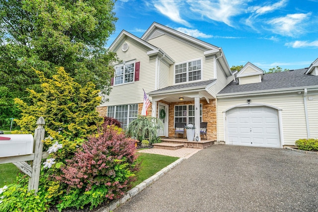 4 Cari Ln, Middle Island, NY 11953 - traditional home featuring an attached garage, covered porch, driveway, stone siding, and a shingled roof