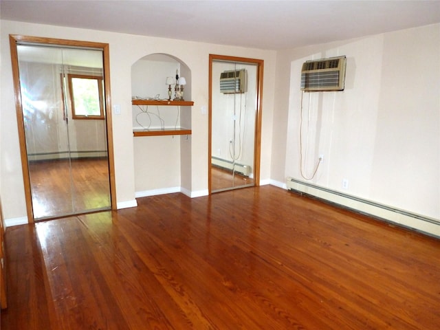 4010 Heywood Rd, Seaford, NY 11783 - empty room with a baseboard heating unit, wood finished floors, and an AC wall unit