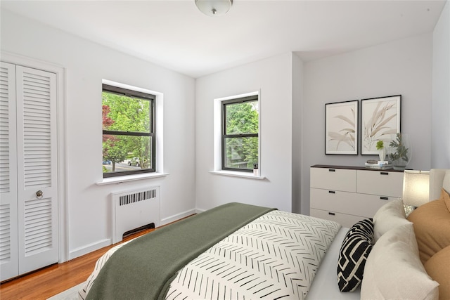 164-03 33rd Ave, Flushing, NY 11358 - bedroom with radiator, multiple windows, wood finished floors, and a closet