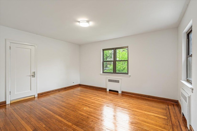 164-03 33rd Ave, Flushing, NY 11358 - empty room with radiator heating unit, hardwood / wood-style floors, and baseboards
