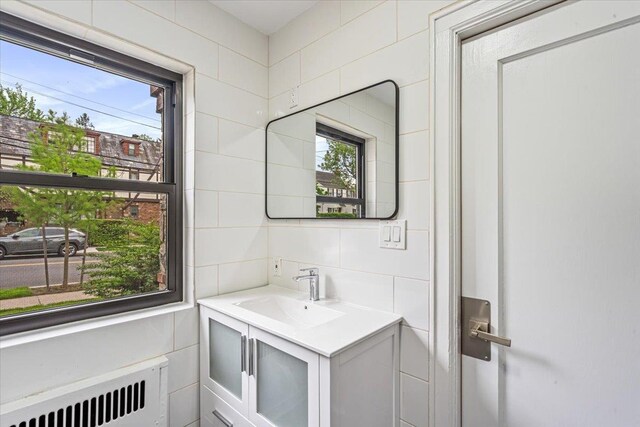 164-03 33rd Ave, Flushing, NY 11358 - bathroom with radiator heating unit, tile walls, vanity, and backsplash