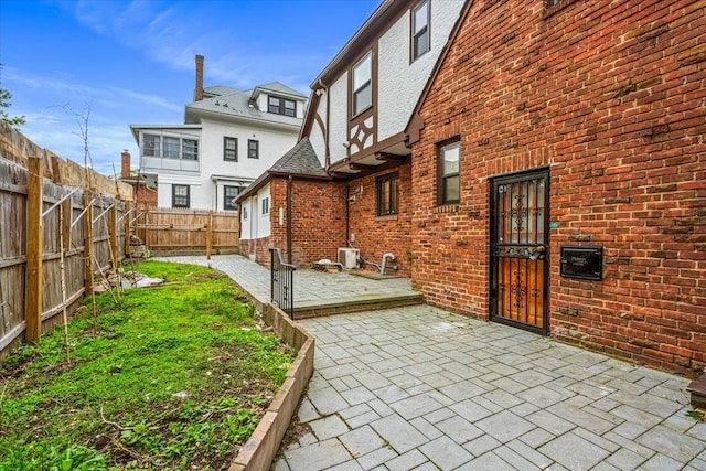 164-03 33rd Ave, Flushing, NY 11358 - back of house featuring a patio, brick siding, a fenced backyard, and central AC unit