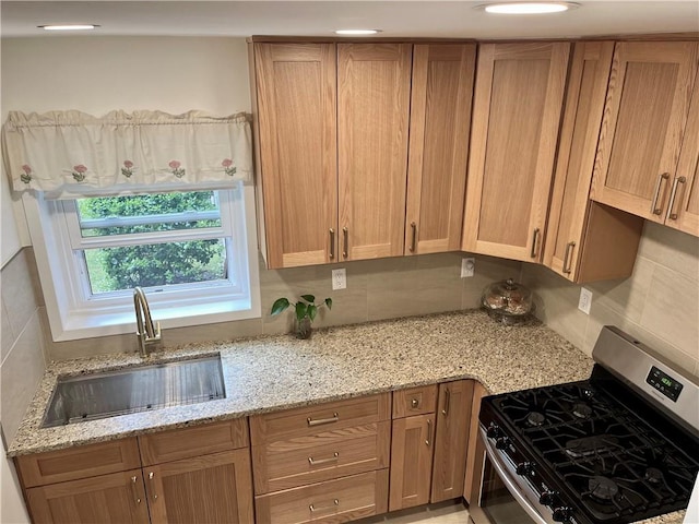 330 S Broadway Unit E2, Tarrytown, NY 10591 - kitchen with stainless steel range with gas stovetop, a sink, backsplash, and light stone countertops