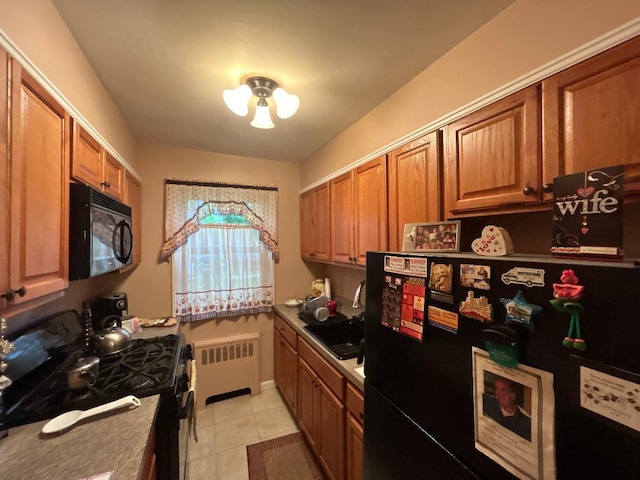 199-58 21st Ave Unit 1-165, Whitestone, NY 11357 - kitchen featuring radiator, black appliances, a sink, light tile patterned flooring, and brown cabinetry
