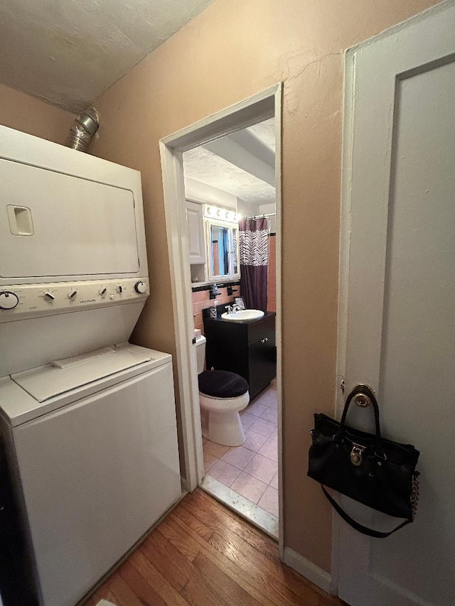 199-58 21st Ave Unit 1-165, Whitestone, NY 11357 - washroom with stacked washer / dryer and wood finished floors
