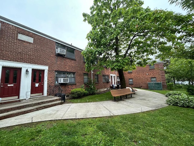 199-58 21st Ave Unit 1-165, Whitestone, NY 11357 - rear view of property with brick siding, a yard, and cooling unit