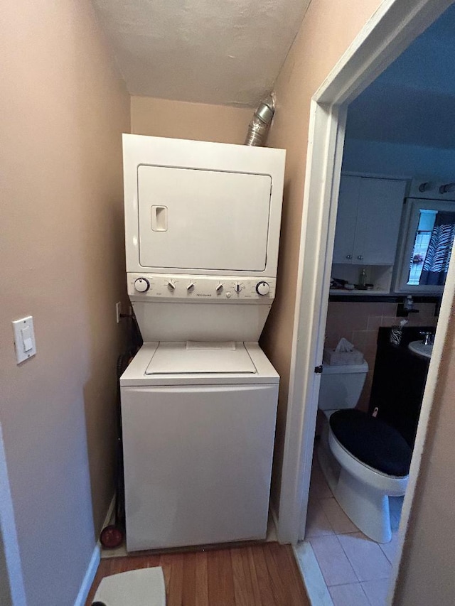 199-58 21st Ave Unit 1-165, Whitestone, NY 11357 - laundry room featuring stacked washing machine and dryer and light wood-type flooring
