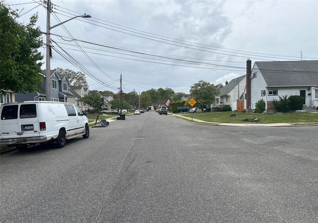 34 Karen St, West Babylon, NY 11704 - view of asphalt road featuring a residential view, traffic signs, and curbs
