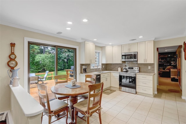 77 Barry Ln, Syosset, NY 11791 - kitchen with stainless steel appliances, light countertops, decorative backsplash, a sink, and crown molding