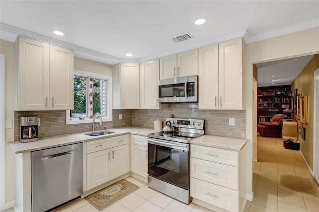 77 Barry Ln, Syosset, NY 11791 - kitchen featuring appliances with stainless steel finishes, a sink, light tile patterned flooring, tasteful backsplash, and recessed lighting