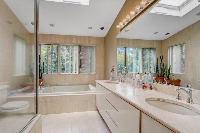 77 Barry Ln, Syosset, NY 11791 - bathroom featuring a bath, double vanity, toilet, a skylight, and tile patterned flooring