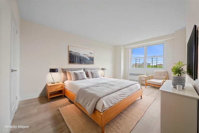 875 Morrison Ave Unit 6E, Bronx, NY 10473 - bedroom featuring radiator, light wood-style flooring, and baseboards