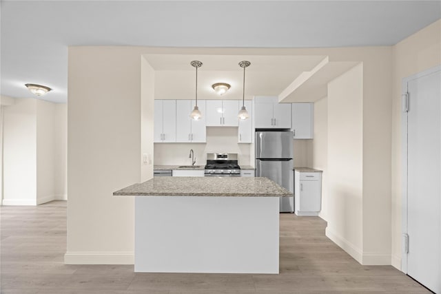 875 Morrison Ave Unit 6E, Bronx, NY 10473 - kitchen featuring stainless steel appliances, a sink, light wood finished floors, baseboards, and white cabinetry