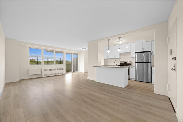 875 Morrison Ave Unit 6E, Bronx, NY 10473 - unfurnished living room with radiator, a sink, light wood-style flooring, and baseboards