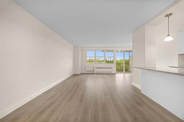 875 Morrison Ave Unit 6E, Bronx, NY 10473 - unfurnished living room with radiator, light wood-style floors, and baseboards