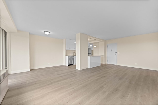 875 Morrison Ave Unit 6E, Bronx, NY 10473 - unfurnished living room with light wood-type flooring, baseboards, and a sink