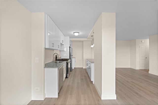875 Morrison Ave Unit 6E, Bronx, NY 10473 - kitchen featuring stainless steel appliances, light wood-style flooring, white cabinetry, baseboards, and light stone counters