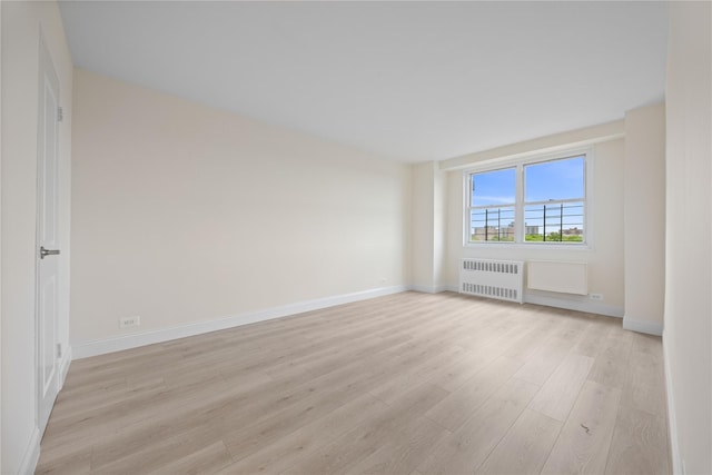 875 Morrison Ave Unit 6E, Bronx, NY 10473 - spare room with radiator heating unit, light wood-style flooring, and baseboards