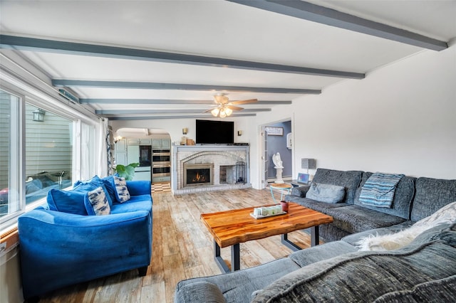 24 Raynor St, West Babylon, NY 11704 - living area featuring beam ceiling, hardwood / wood-style floors, a ceiling fan, a fireplace, and arched walkways