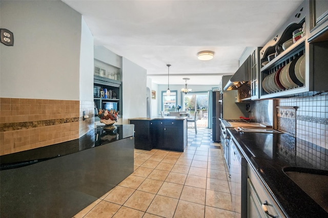 24 Raynor St, West Babylon, NY 11704 - kitchen featuring light tile patterned floors, a center island, dark countertops, dark cabinets, and decorative light fixtures