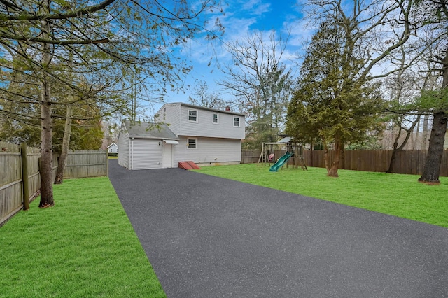 12 Barberry Ln, Middle Island, NY 11953 - view of front of house with a playground, a chimney, driveway, and a detached garage
